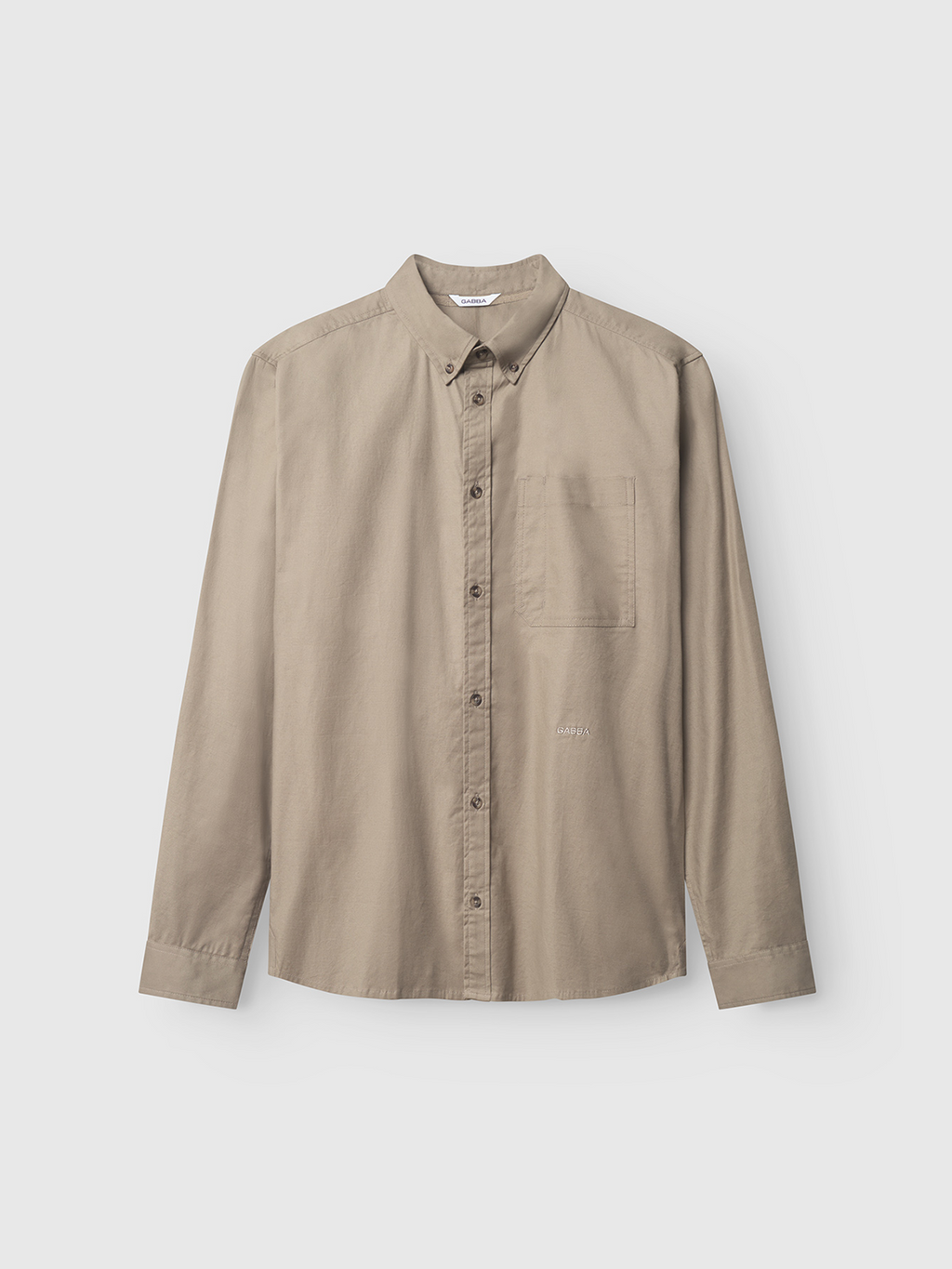 The Bent Reg Ox LS by Gabba is a khaki long-sleeve button-up shirt with a classic collar and left-side front pocket, offering timeless design and versatility. The subtle brand detailing completes its appeal, showcased against a plain light background.