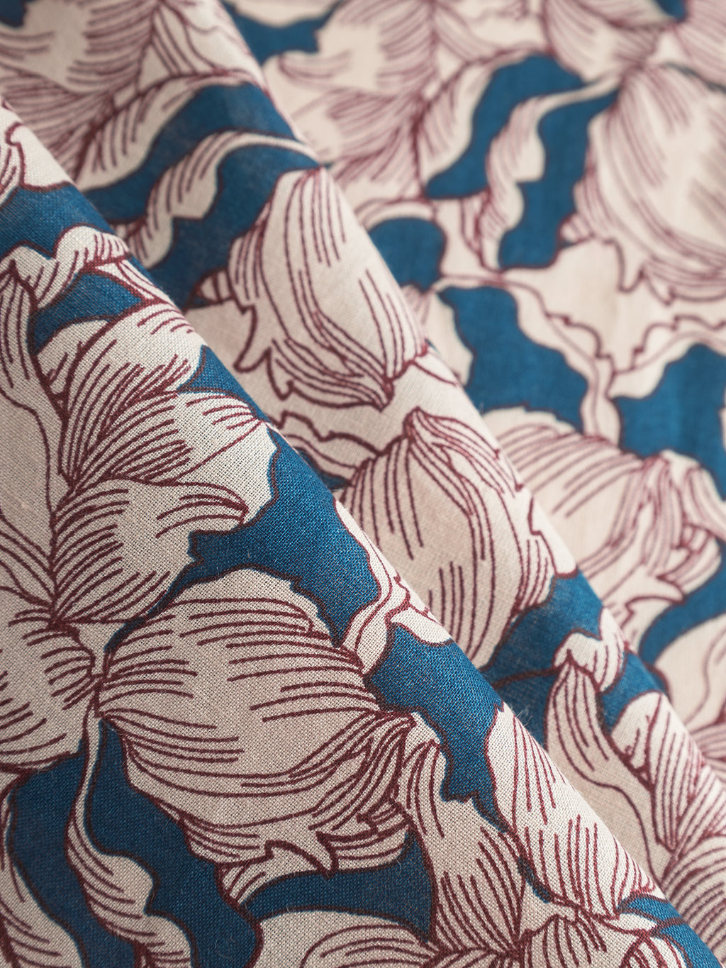 The Bandana Epo - Blue Pattern from Gabba features a retro flower design with maroon outlines and blue accents on a beige background, crafted from soft cotton for a textured and elegant look reminiscent of a classic bandana.