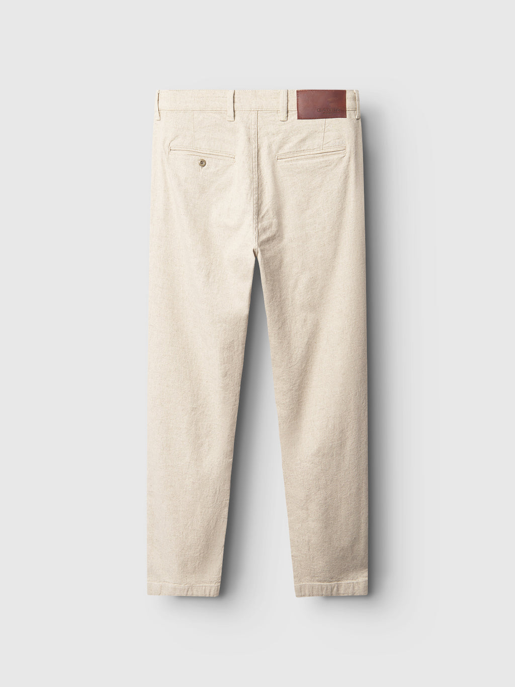 The Gabba Kyoto Hemp trousers in Sand are displayed from the back, featuring two buttoned pockets and a leather patch on the waistband. They offer a relaxed tapered fit for ultimate comfort against a light gray background.