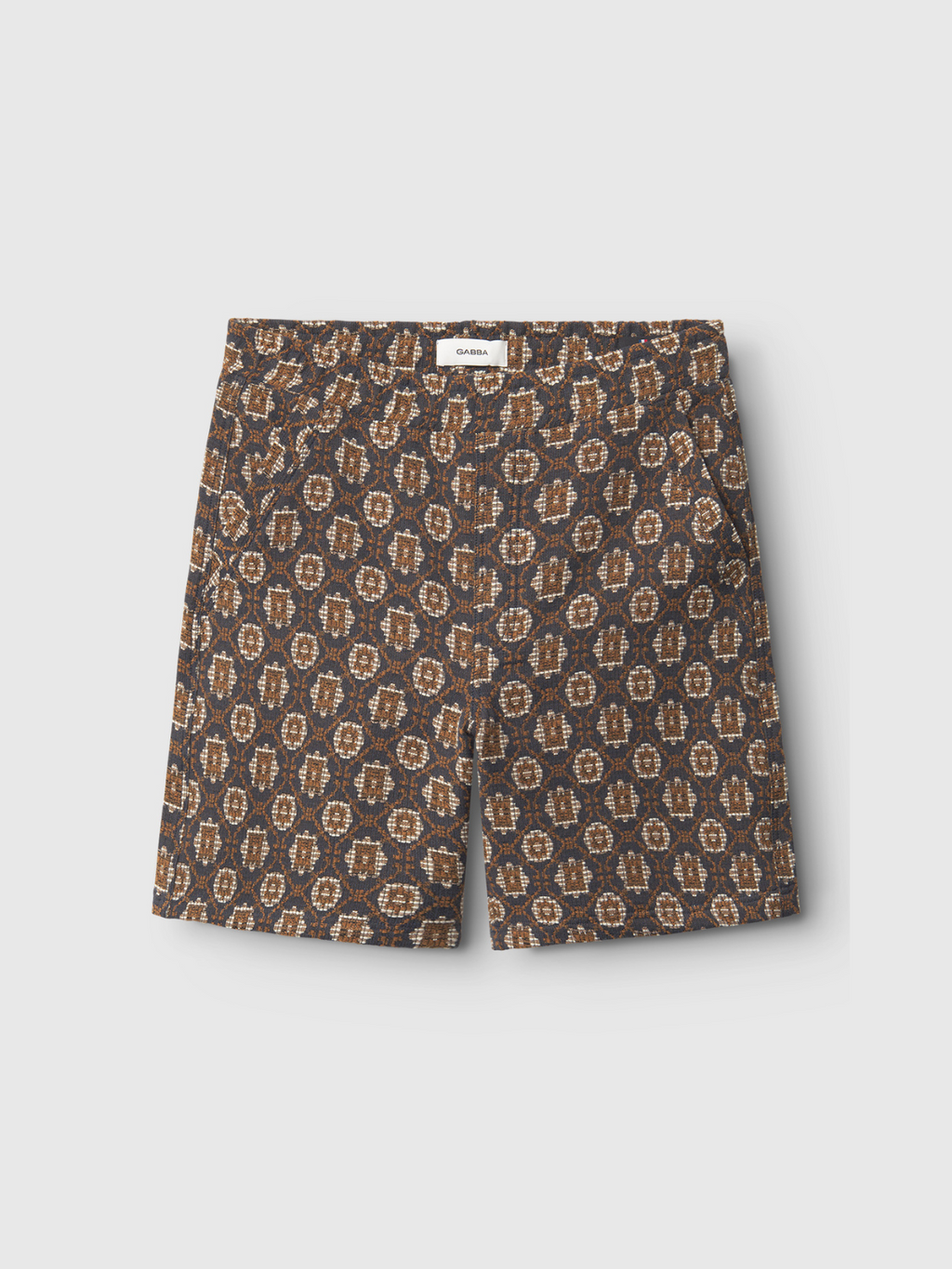 The Gabba Fede Box Star shorts feature a boxy fit and multi geometric patterns in beige and tan, with side pockets and a button above the fly—a bold choice for lovers of relaxed style.
