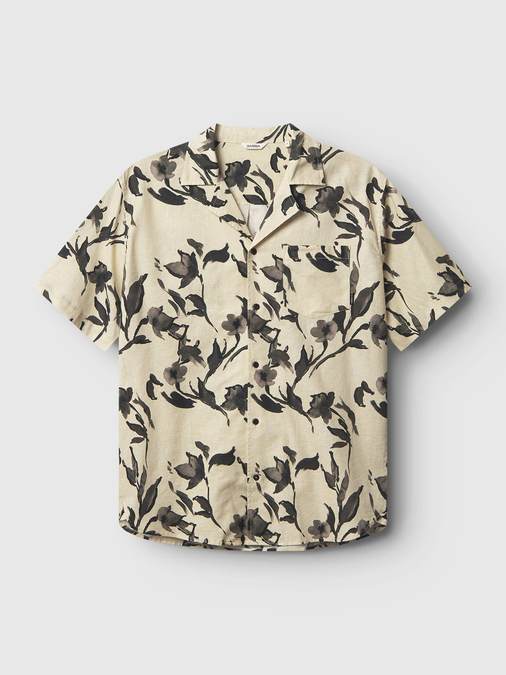 The Gabba Sven Reg Resort Bloom SS - Meteorite is a premium beige short-sleeve shirt featuring an exquisite black flower print. Made from fine linen, it includes a collar, front buttons, and a single chest pocket.