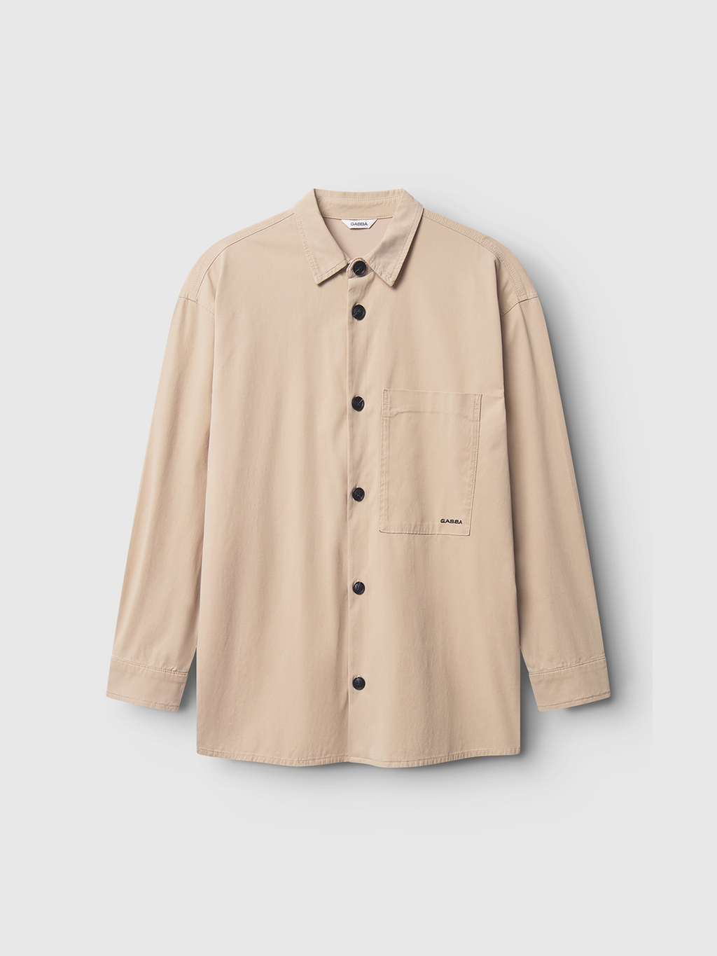 The Gabba Jens Over Lubo LS - Sand is a beige long-sleeve button-up shirt with a collar, black buttons, and a left chest pocket. Made from lightweight summer fabric for comfort, its shown laid flat on a plain white background.