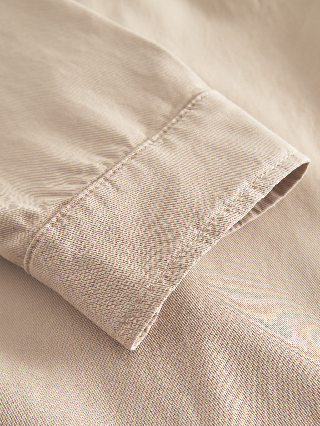 Close-up of the Jens Over Lubo LS - Sand by Gabba, highlighting the beige fabric sleeves premium shirt-like material with visible stitching. The focus is on the cuff, showcasing its soft, smooth texture and seam detail.