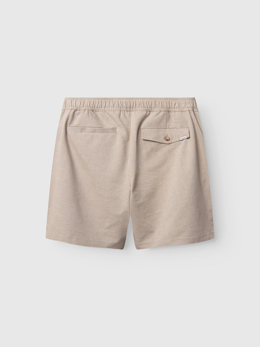 The Gabba Coz Belt Carre Shorts in Sand feature an elastic waistband, two back pockets, and a buttoned flap on the right pocket. Shown flat on a light gray background.