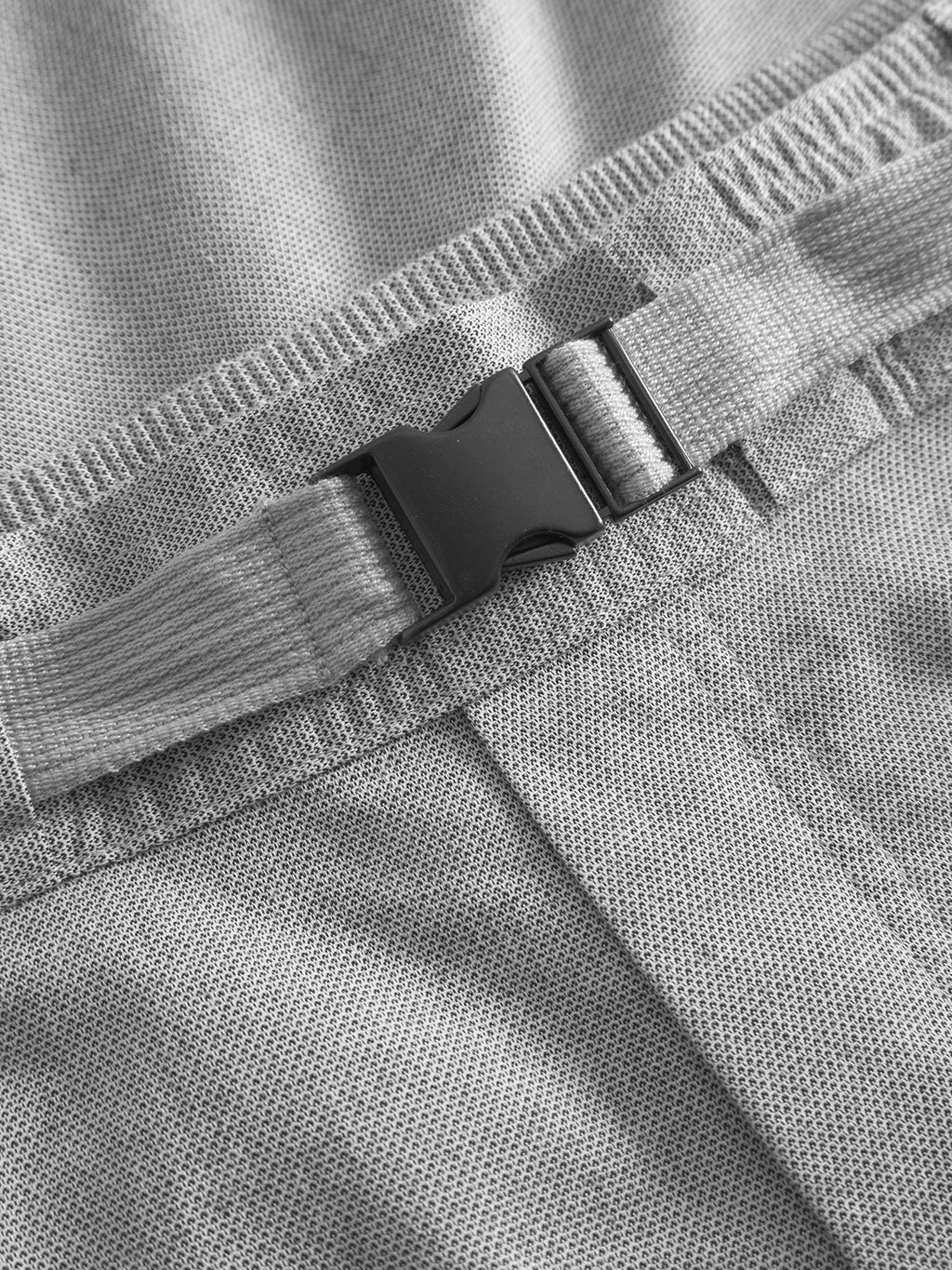 Close-up of the Coz Belt Carre Shorts by Gabba in light grey, featuring a black plastic buckle on a distinct belt strap. The fabrics texture is visible, and the horizontal buckle is securely fastened for optimal comfort.
