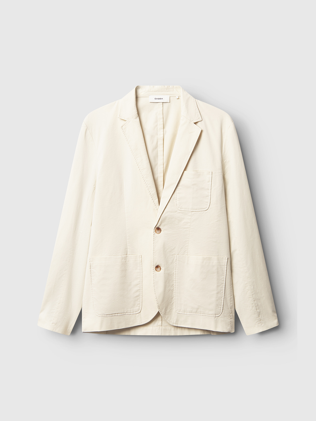 The Gabba Josh Unite blazer in beige is a premium regular-fit, cotton-stretch jacket with two front patch pockets, a chest pocket, and two buttons, showcased against a light gray background.