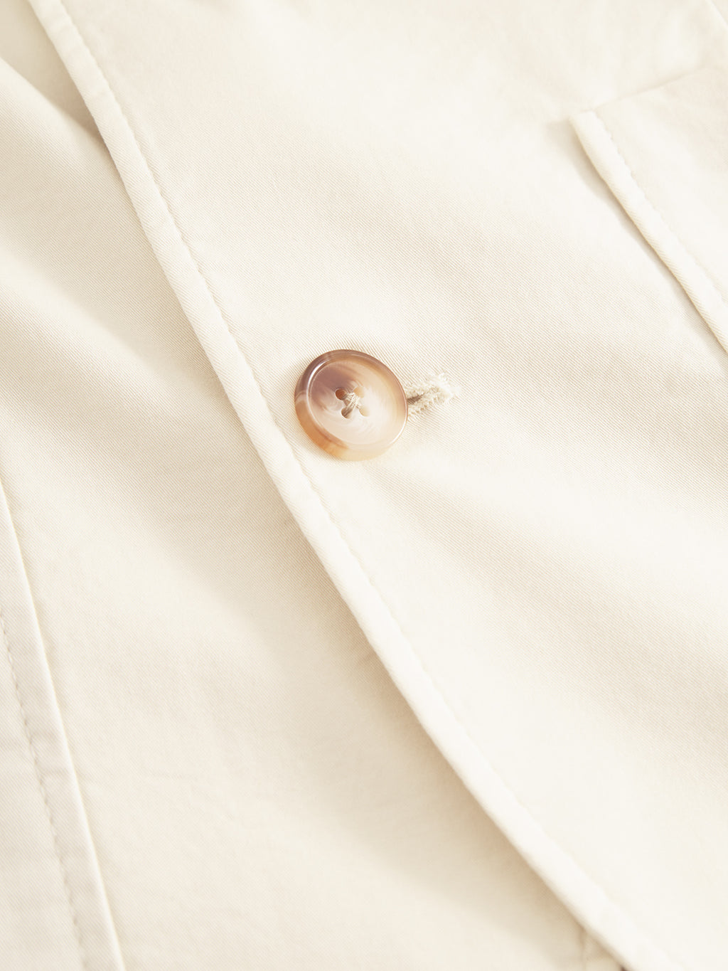 Close-up of the Gabba Josh Unite blazer in beige, featuring a beige cotton stretch fabric with a glossy brown button. The smooth texture and distinct stitching highlight the craftsmanship of this premium regular-fit garment, with its securely stitched button adding elegance.