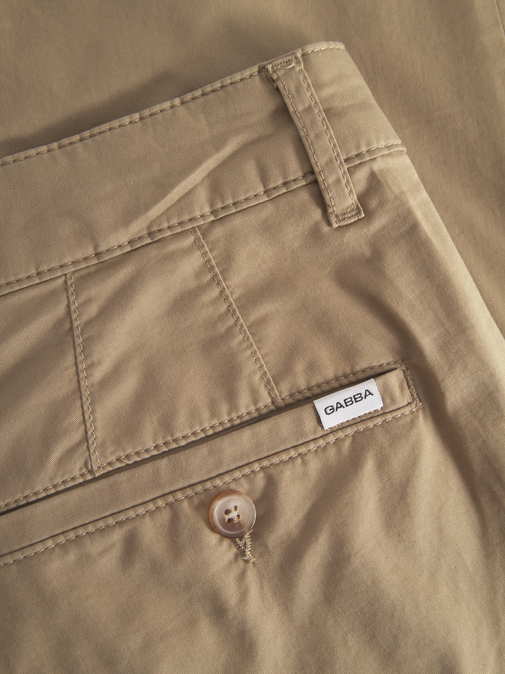 Close-up of the Gabba Monza Unite - Sand relaxed straight pant pocket featuring a buttoned flap, visible stitching, belt loop, classic silhouette, and a white GABBA fabric label.