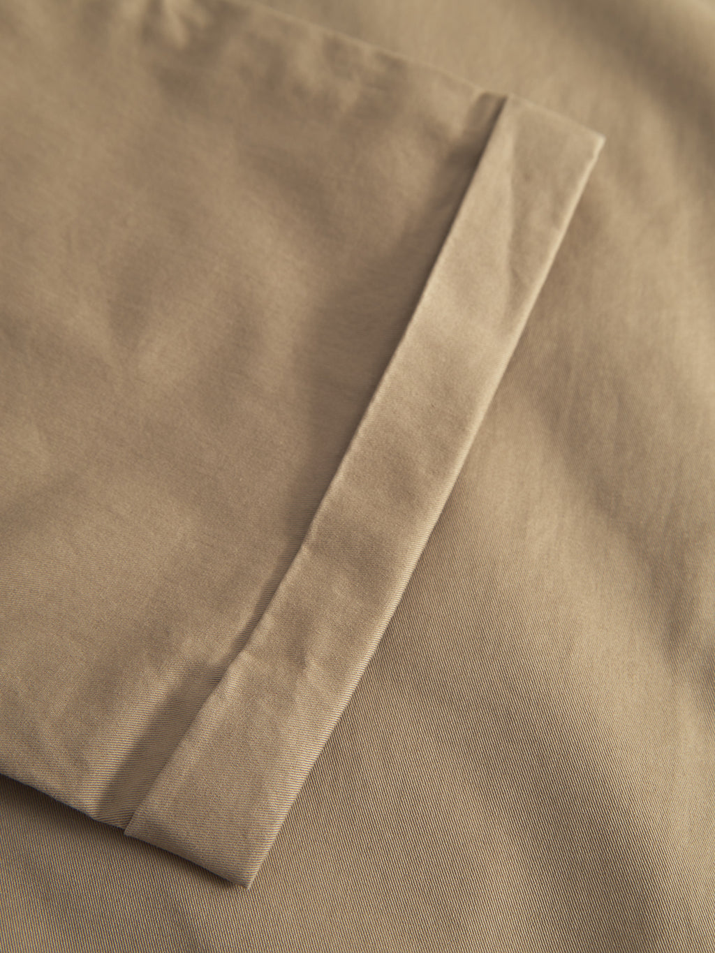 Close-up of Gabba’s Monza Unite - Sand, showcasing neatly folded fabric with a smooth texture and clean edges—ideal for a relaxed straight pant with a classic silhouette, all under soft lighting.