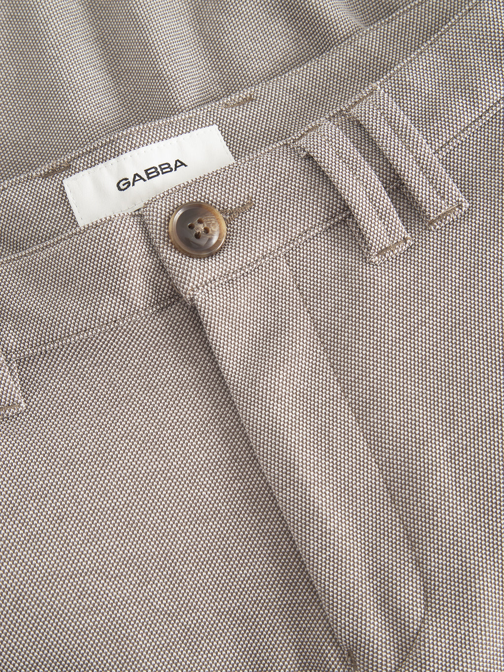 A close-up of Gabbas Jet Tink - Khaki pants, showcasing their beige textured fabric, a brown button, belt loops, and a durable finish.