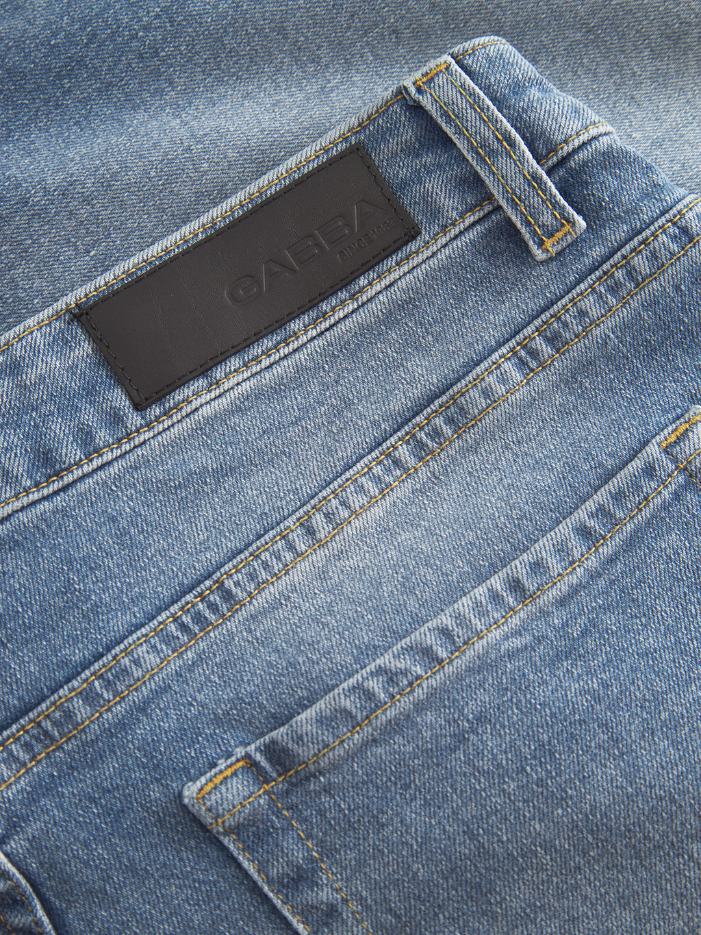 Close-up of Gabbas Markus 5poc - Mid Blue Denim jeans, focusing on the back pocket and black leather patch on the waistband. The texture and stitching details emphasize its comfortable fit.