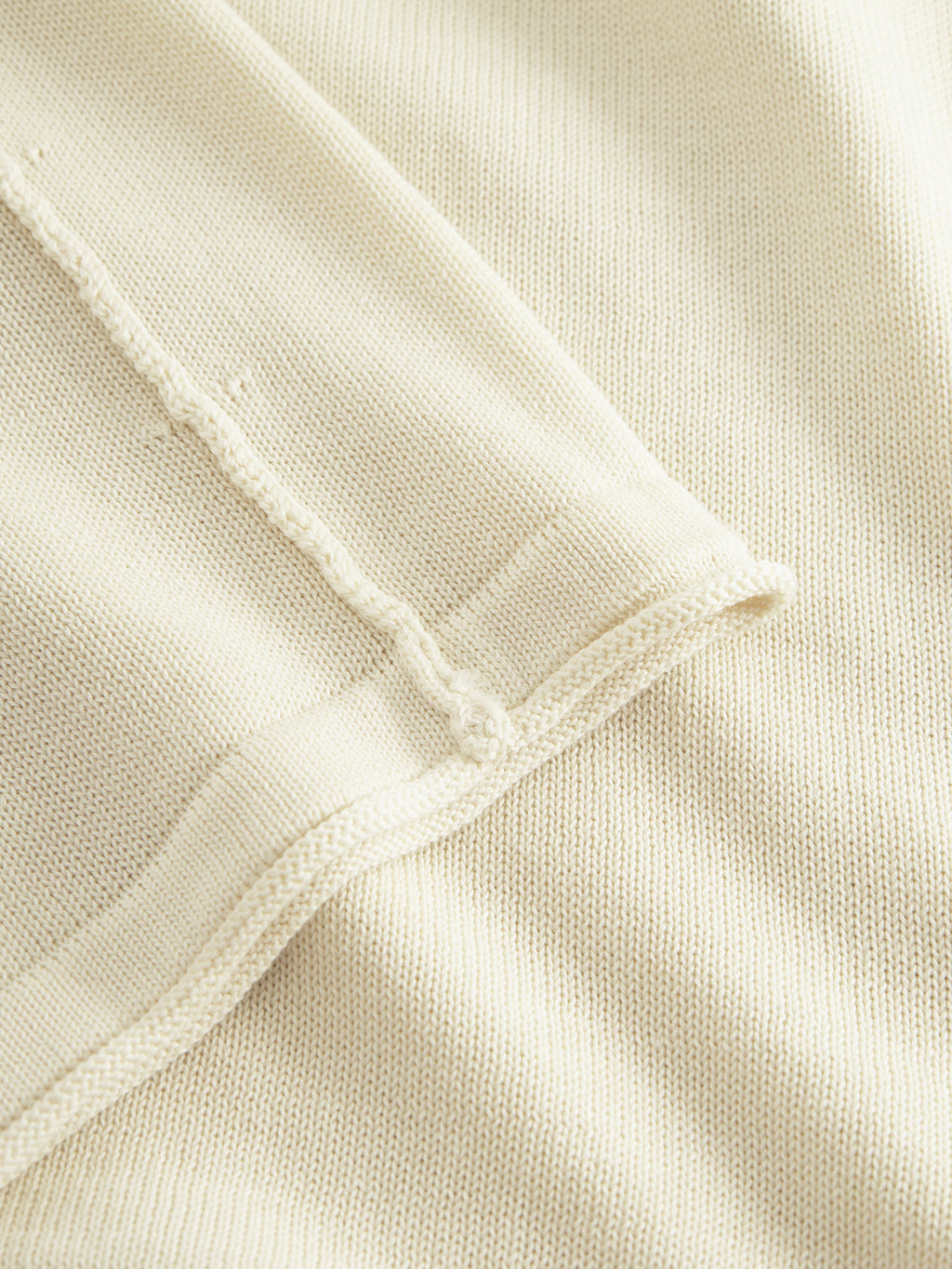 Close-up of Gabbas Bela Fix LS - Ecru Light, highlighting its textured stitching and overlapped seam. Made from 100% cotton, this beige knit fabric offers exceptional comfort while being soft and lightweight.
