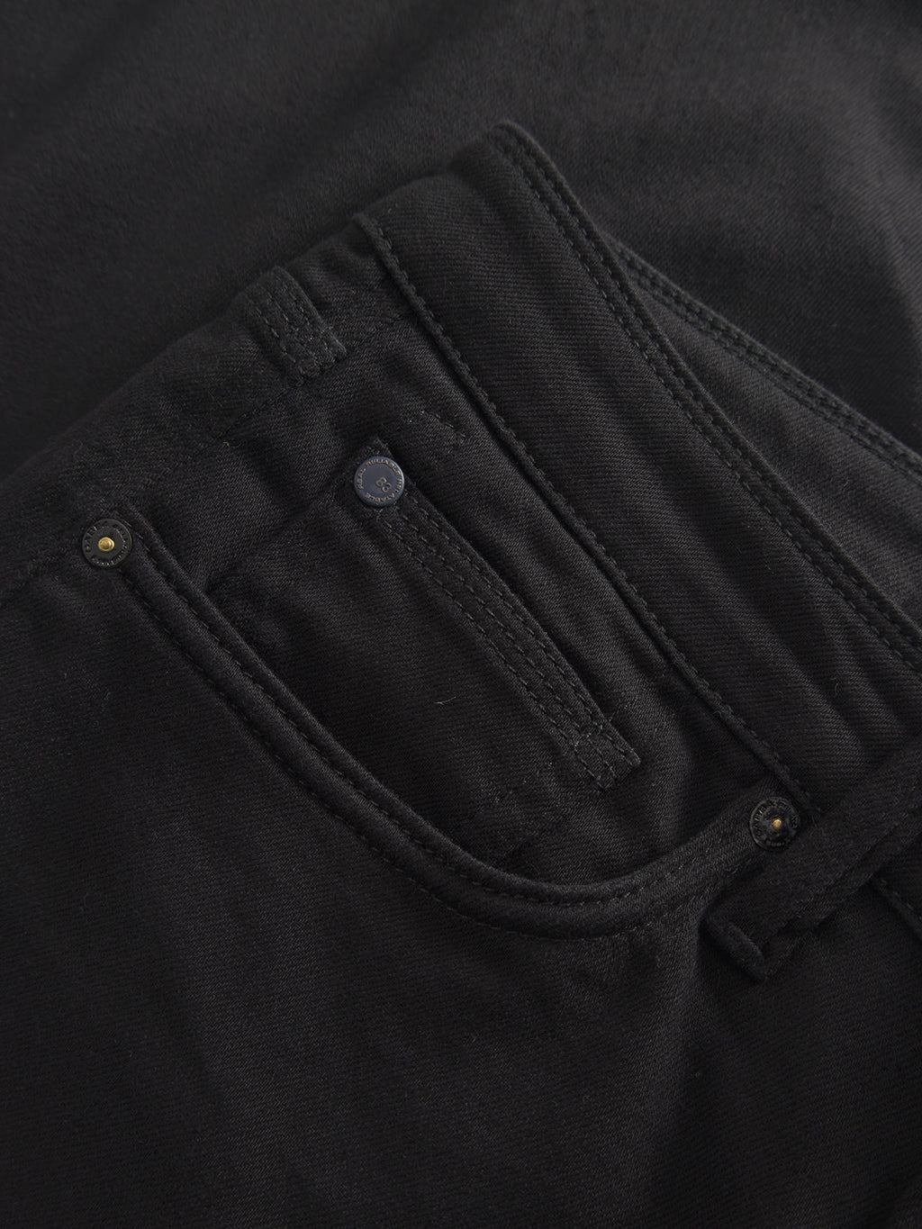 Close-up of Gabbas Max Sword black denim reveals a front pocket with a subtle button detail and visible stitching that emphasizes the sleek craftsmanship and modern slim fit of the fabric.