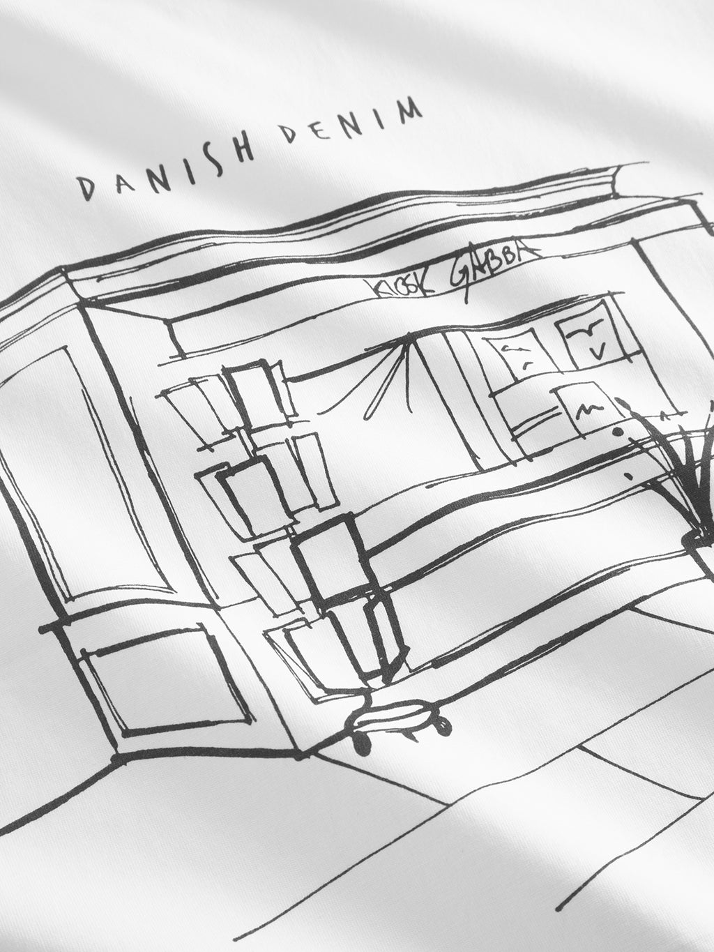 The Dune Kiosk A SS GOTS - White, by Gabba, features a black line drawing of a storefront on Danish Denim. It showcases large windows and a door on a white background on organic cotton for an eco-friendly touch.