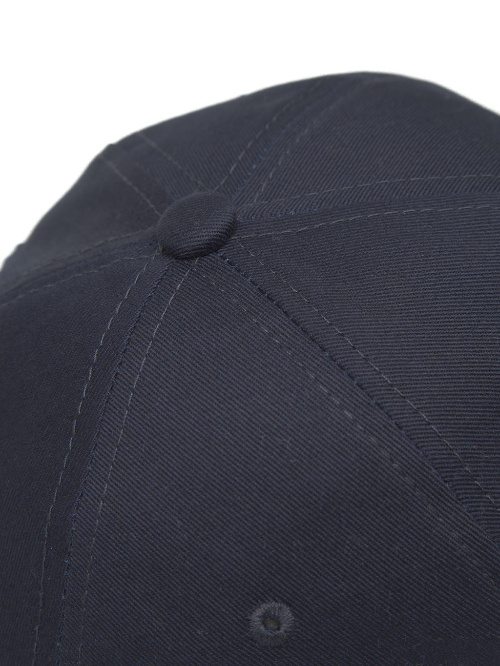 The Cashier Cap - Night Sky by Gabba features a close-up view of its dark twill fabric, showcasing detailed stitching and texture. The central button and panel seams accentuate the caps design.