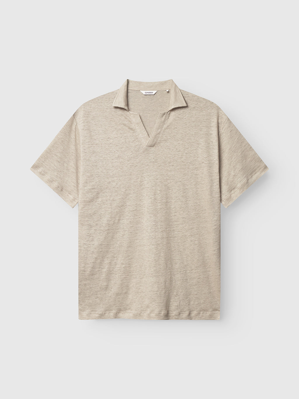 The Trevor - Sand Plaza by Gabba is a beige, short-sleeved polo shirt with an open collar set against a plain, light background. Designed for superior comfort, this casual and simple shirt is perfect for everyday wear.