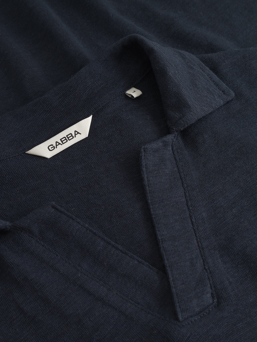 Close-up of the Trevor - Navy, a dark navy collared shirt by Gabba, crafted from textured fabric for comfort. It features a simple open-front placket without buttons, offering premium t-shirt quality with elegance.