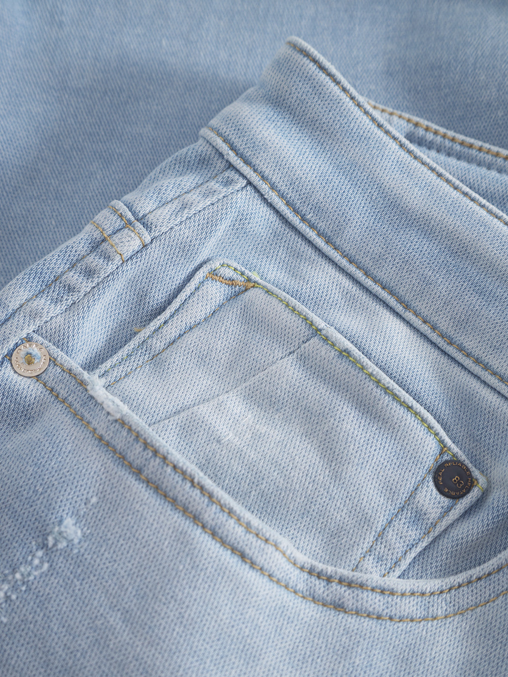 Close-up of Gabbas Jason K3787 SANZA Shorts in light blue denim, highlighting side and back pockets. The super-stretch fabric has a subtle texture with stitching details, and the pockets feature brass rivet accents.