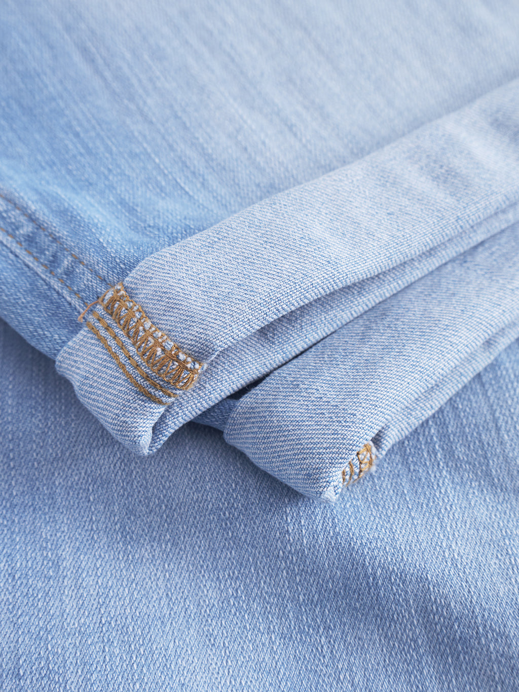 Close-up of Gabbas Markus Selvedge Shorts Limited in light blue denim, showing visible stitching. The neatly folded fabric highlights texture and weave, promising a comfortable fit.