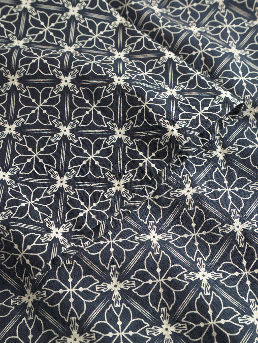 The premium fabric of Gabbas Timo Resort AOP SS - Navy shirt showcases a detailed white floral and geometric pattern on a dark background, featuring stylized flowers in diamond frames for a textured and elegant look.