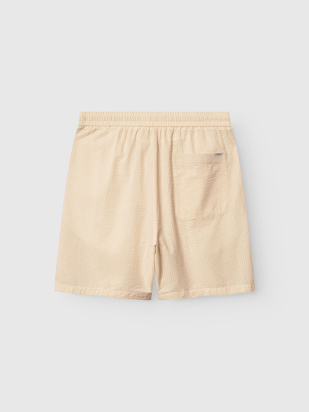 The Tommi Seer - Ecru Light shorts by Gabba are crafted from textured seersucker fabric, featuring an elastic waistband and a single back pocket. They are displayed on a light gray background.