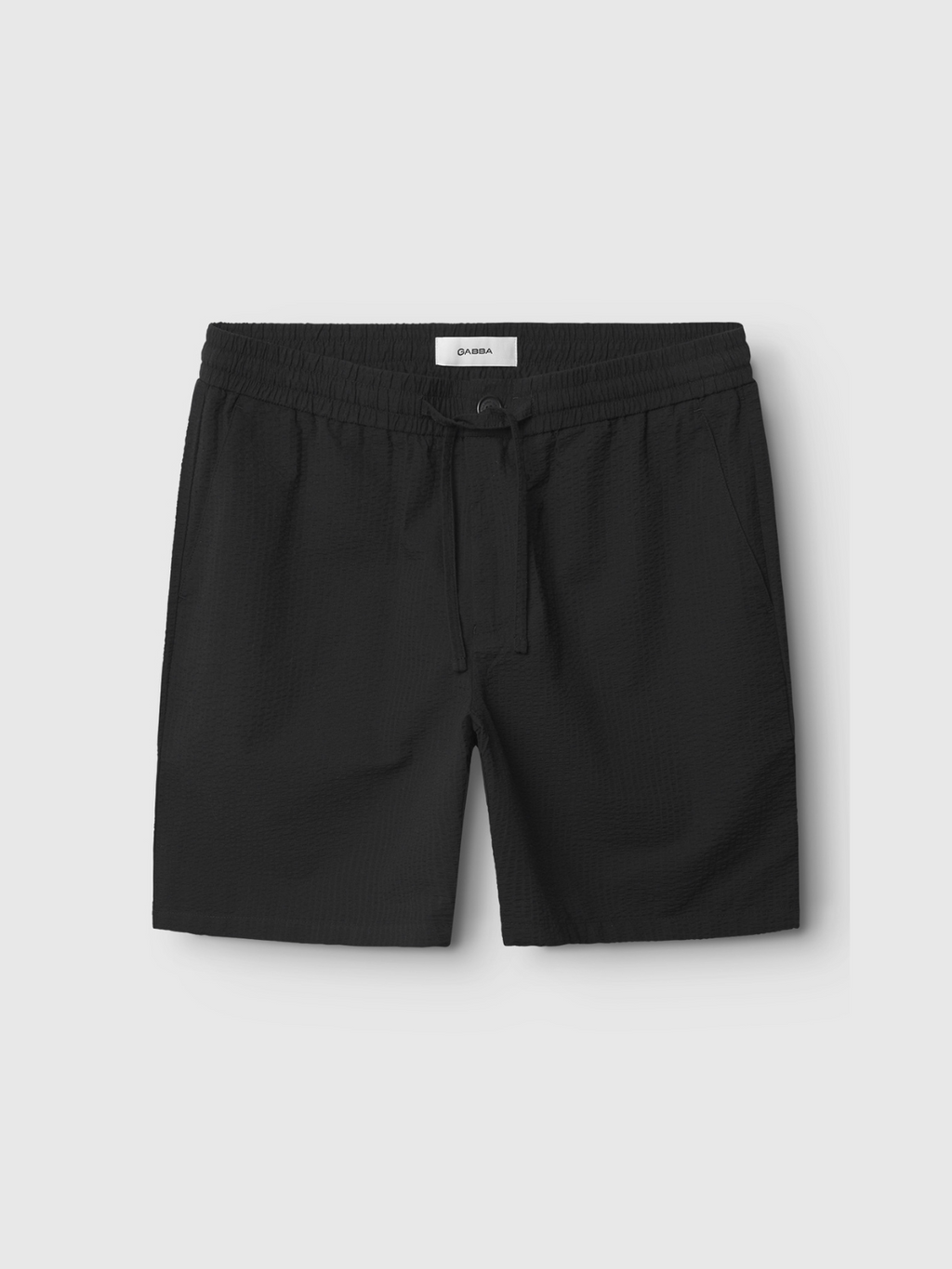 The Gabba Tommi Seer - Black shorts feature a seersucker fabric, elastic waistband, and side pockets, shown against a plain light gray background.