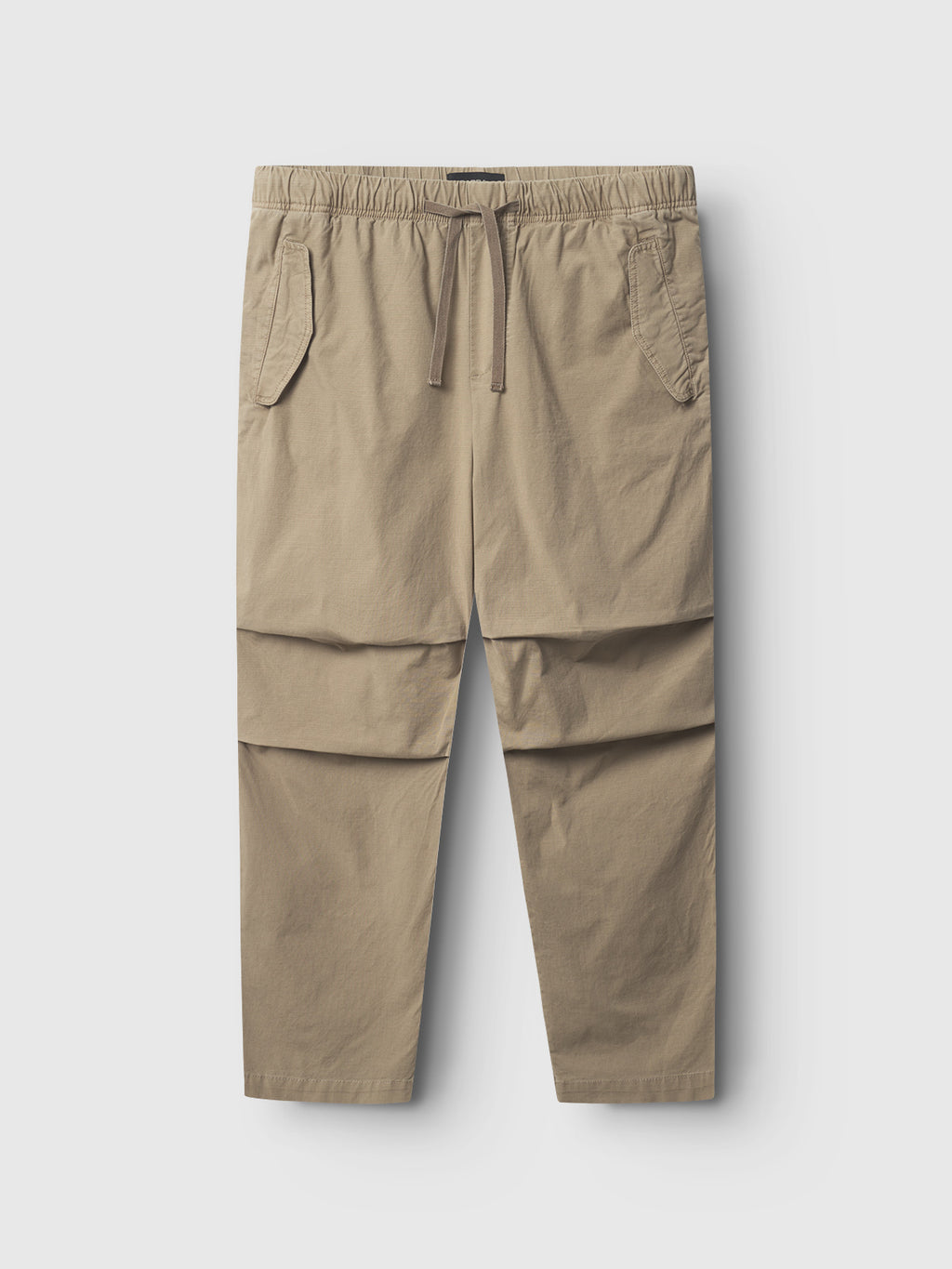 The Gabba Topgun Jash - Sand pants, made from durable khaki ripstop fabric with an elastic waistband and two side pockets, are laid flat against a light gray background.