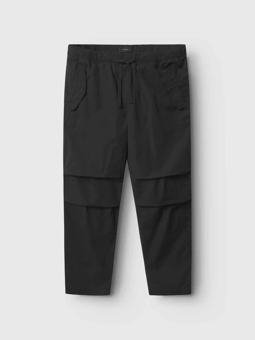 Introducing the Topgun Jash - Black cargo pants by Gabba. Crafted from durable ripstop fabric with an elastic waistband and drawstring, they feature multiple pockets, including two large side flaps, all in a relaxed fit on a plain light background.