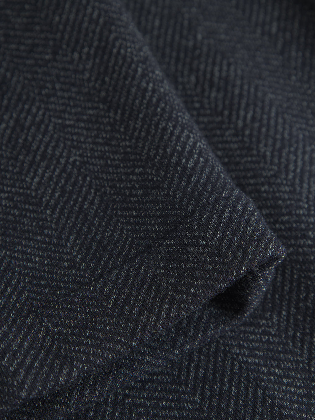 Close-up of navy, elegant tweed fabric by Gabba, with a subtle herringbone pattern and diagonal zigzag lines. The soft, tightly woven texture adds depth and sophistication. Perfect for Monza Tweed pants.