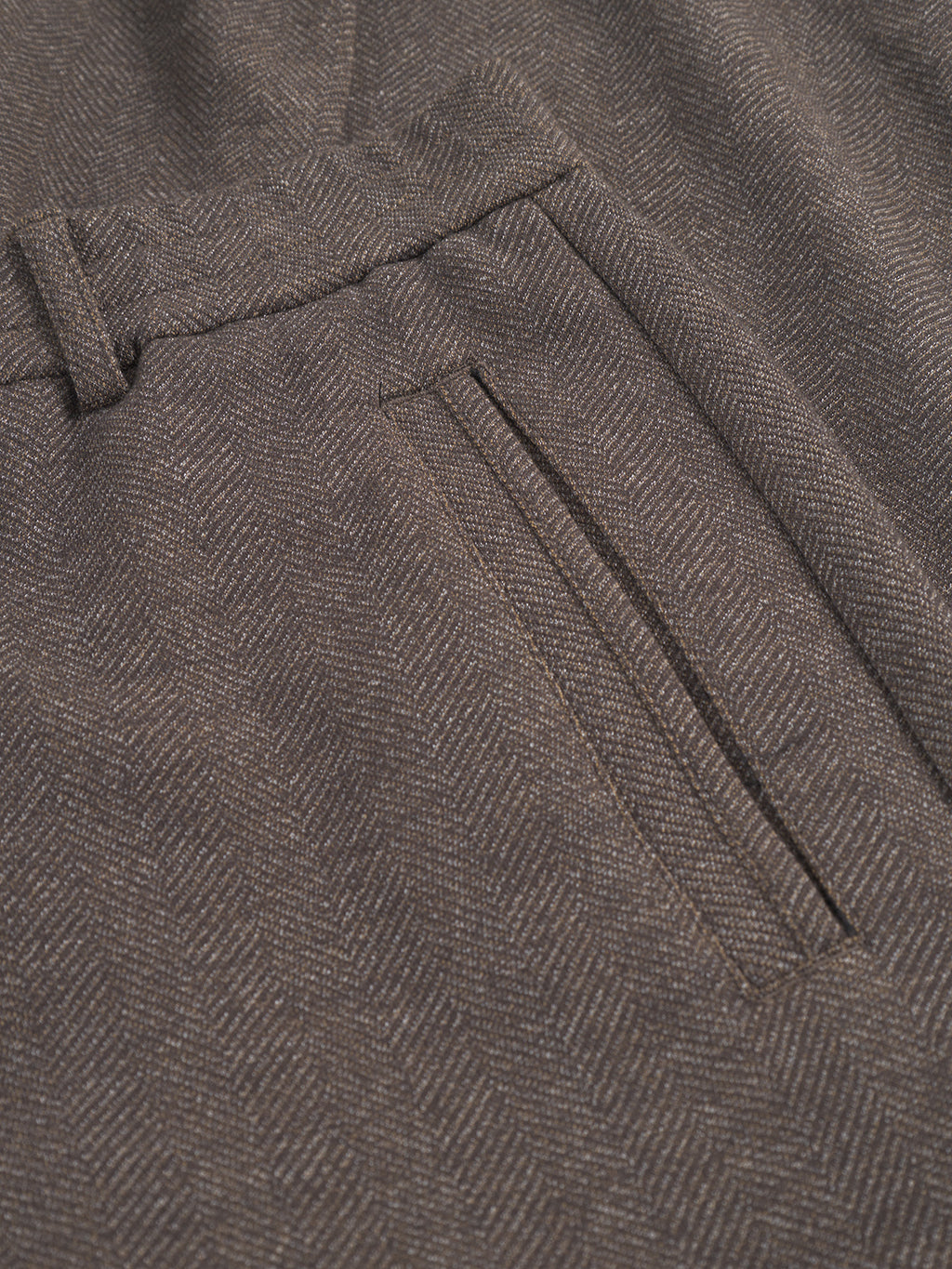 Close-up of the Monza Tweed - Brown trousers by Gabba, showcasing the elegant herringbone pattern and straight-line pocket design. The detailed texture and subtle color variations enhance their sophisticated look.