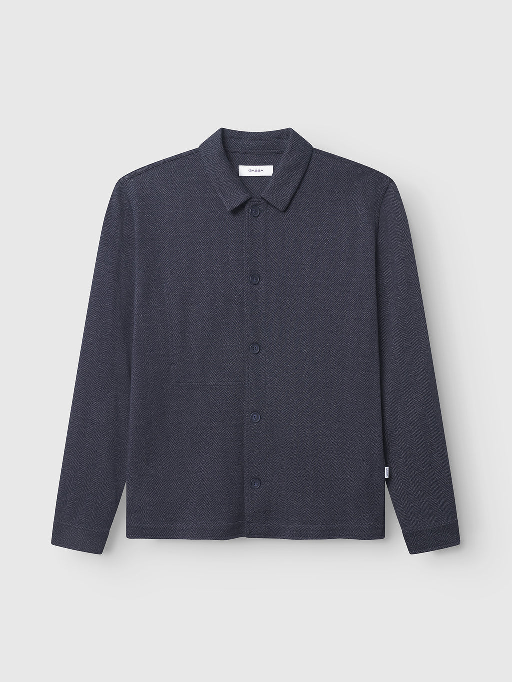 The Peter Tweed - Navy by Gabba is a dark gray long-sleeve shirt featuring a button-front closure and classic collar, showcasing timeless style against a plain light gray background.