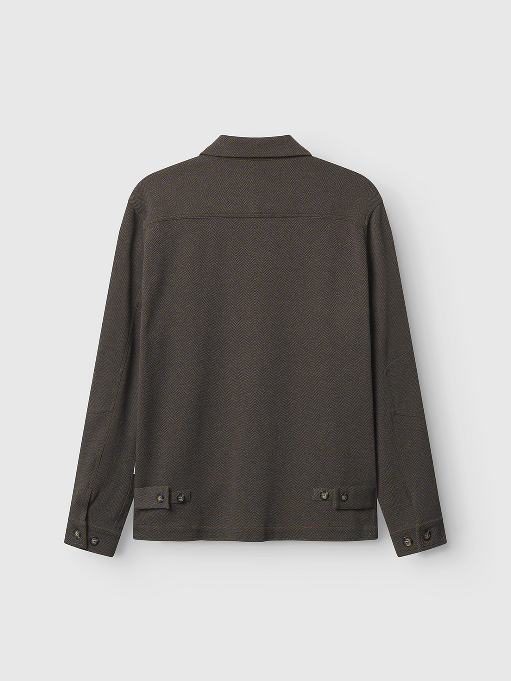 The Peter Tweed - Brown by Gabba is showcased from the back on a light gray background. This dark olive green button-up jacket features a sophisticated design with long sleeves, a tailored fit, and buttoned tabs at the back hem and cuffs.