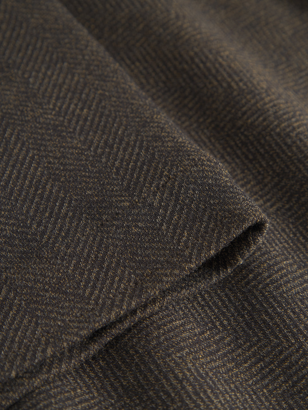 Close-up of Gabbas Peter Tweed - Brown, a dark brown fabric with a subtle herringbone pattern, reminiscent of the sophisticated design of a classic tailored tweed jacket.