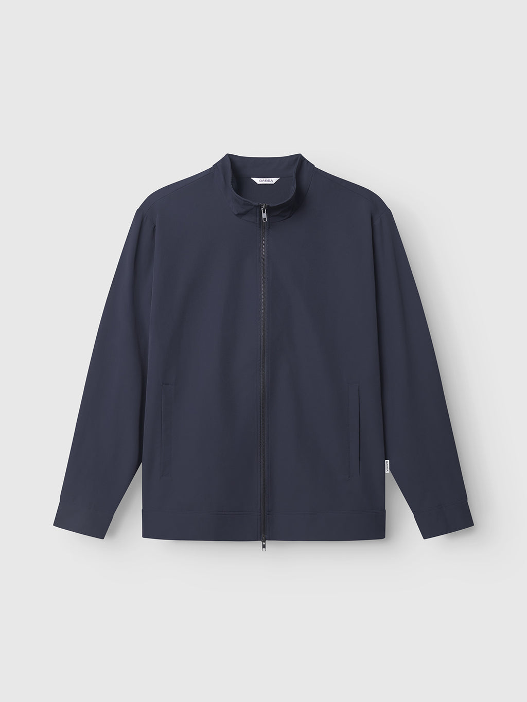 The Gabba Nik Tech - Navy is a navy blue tech-material jacket with long sleeves, zipper front, stand-up collar, and two side pockets—ideal for an active lifestyle. Shown against a plain light grey background.