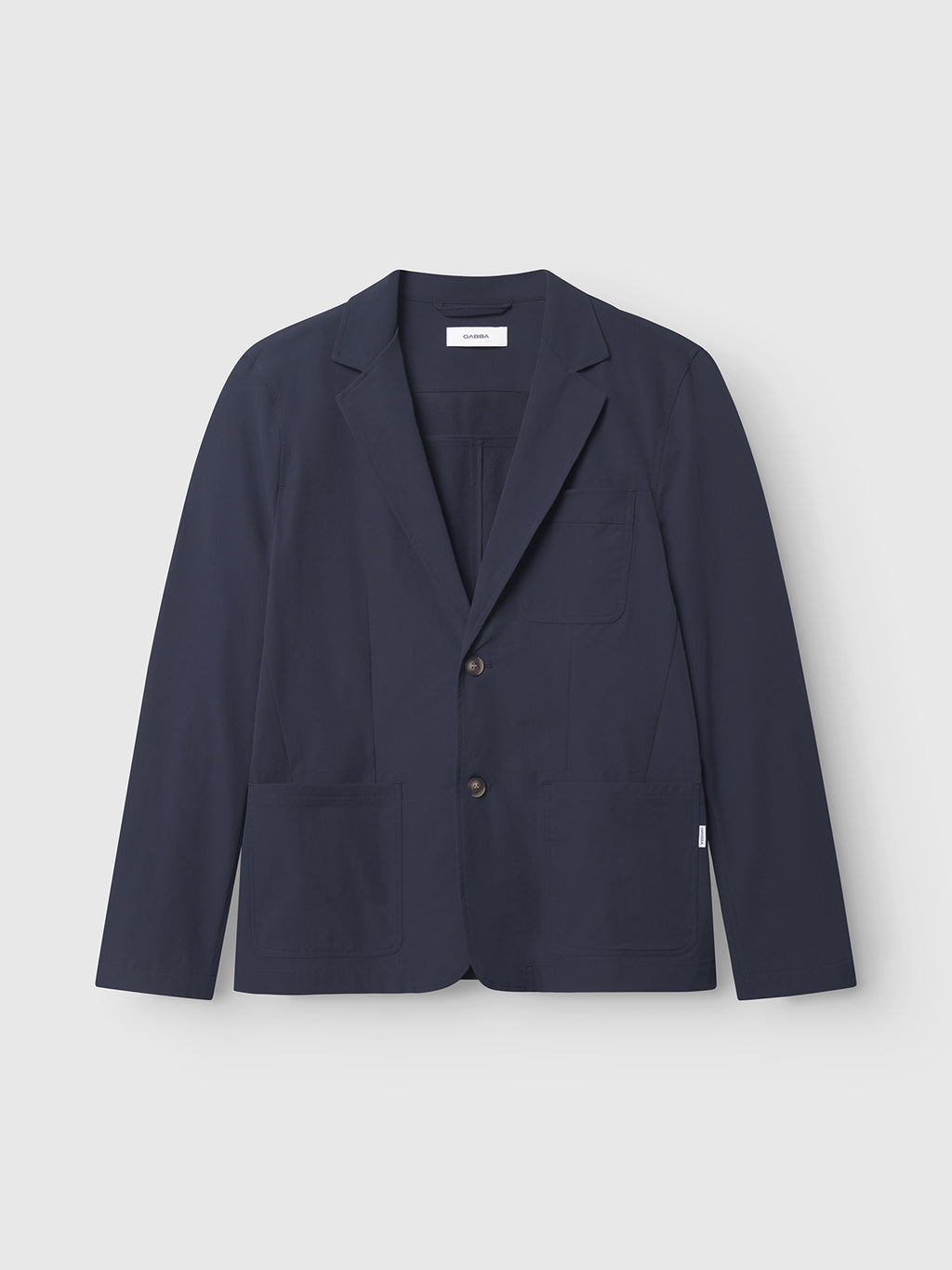 The Plaza Tech - Navy by Gabba is a navy blue, tailored fit blazer featuring a notched lapel, two front buttons, and three spacious patch pockets on the front, showcased against a plain white background.