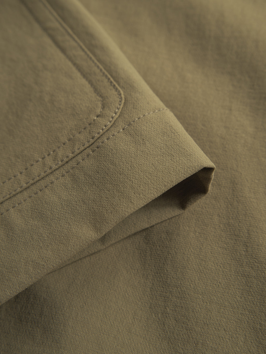 Close-up of Gabbas Plaza Tech - Army fabric reveals its olive green shade with precise stitching, mimicking a tailored fit. The texture and seam details highlight the precision characteristic of this tech jacket.