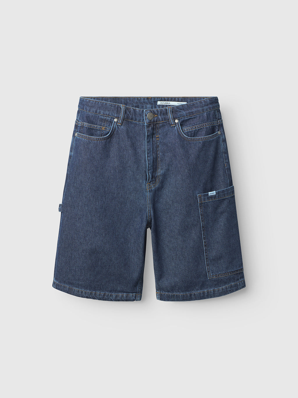 The Gabba Ugo Cargo Fone shorts, in mid-blue denim, feature a classic five-pocket and extra utility pocket design. Ideal for workwear lovers, they offer belt loops and stitching details in a loose fit against a simple light gray background.