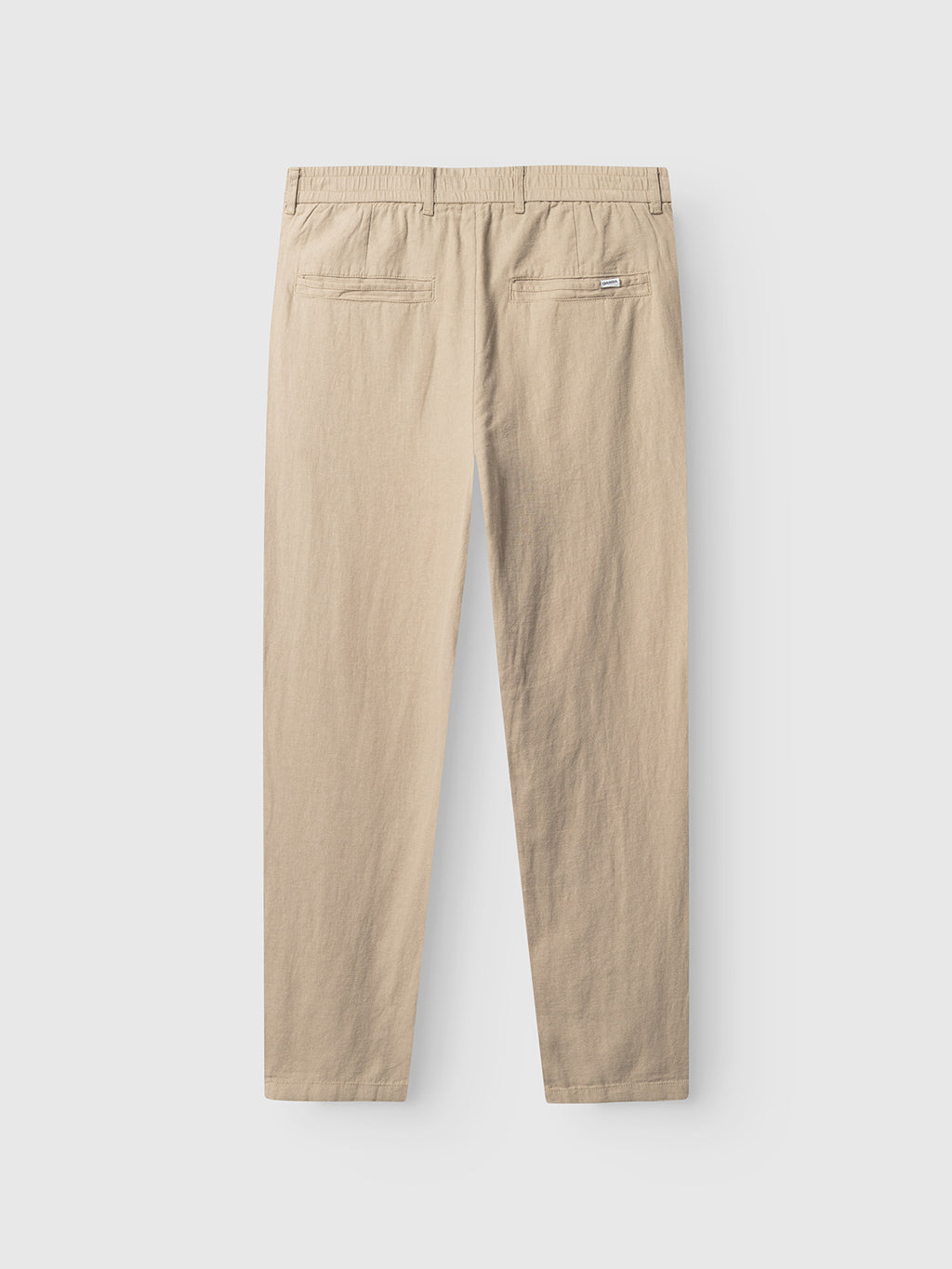 The Monza Lino Cropped - Sand Plaza trousers by Gabba are shown from the back, highlighting an elastic waist and two back welt pockets with a classic silhouette, set against a plain white background.
