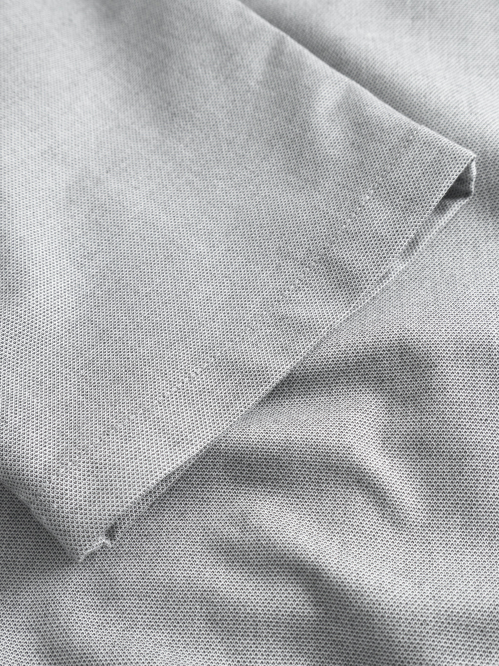 Close-up of light grey textured weave fabric from Gabbas Napoli 19 Carre pants, folded at the corner, showcasing its classic style and promising comfort.