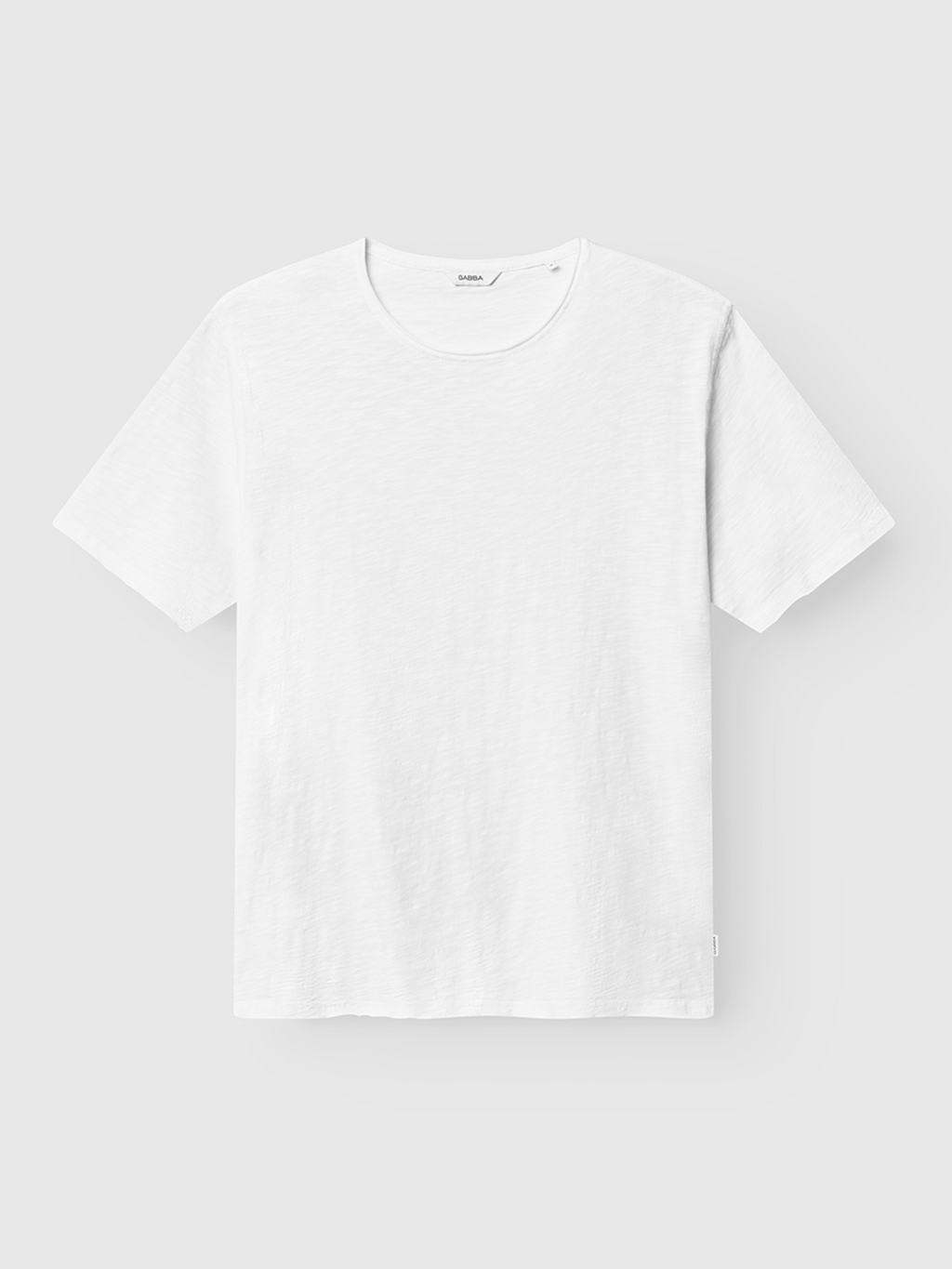The Gabba Kostant New SS - White is a lightweight, breathable slub yarn T-shirt with minimal styling and a crew neckline, shown flat on a light grey background. This short-sleeve tee is plain white with no visible logos or designs.
