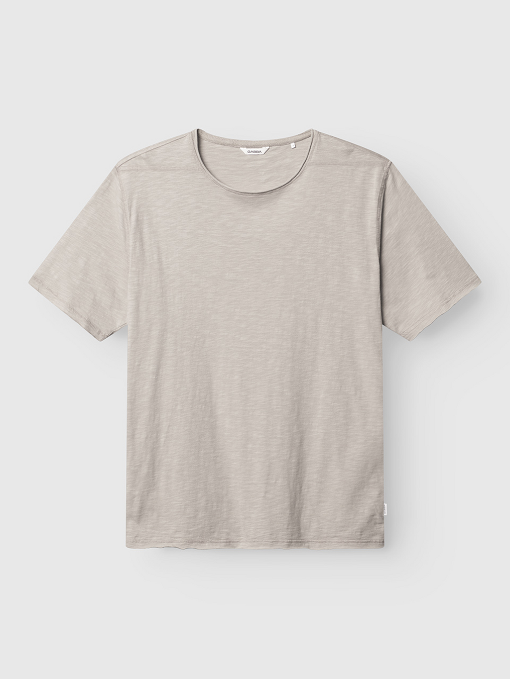 The Gabba Kostant New SS - Grey Paloma is a plain, short-sleeved light gray t-shirt with a slub texture, crew neckline, and relaxed fit, shown laid flat on a white background with no visible logos or designs.