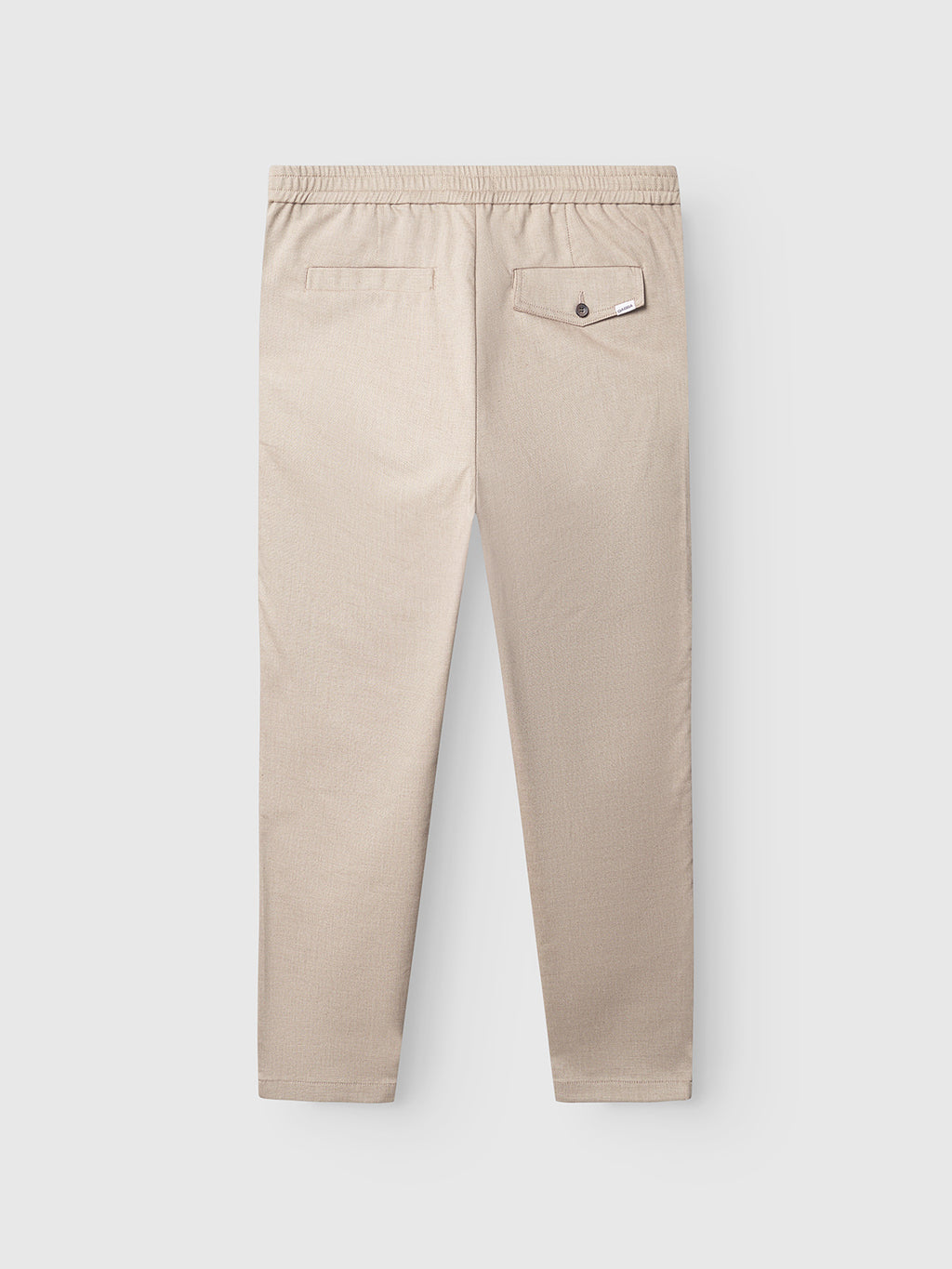 The Gabba Monza Button Carre pants in sand display their relaxed fit from the back, featuring an elastic waistband and two rear pockets, one adorned with a flap.