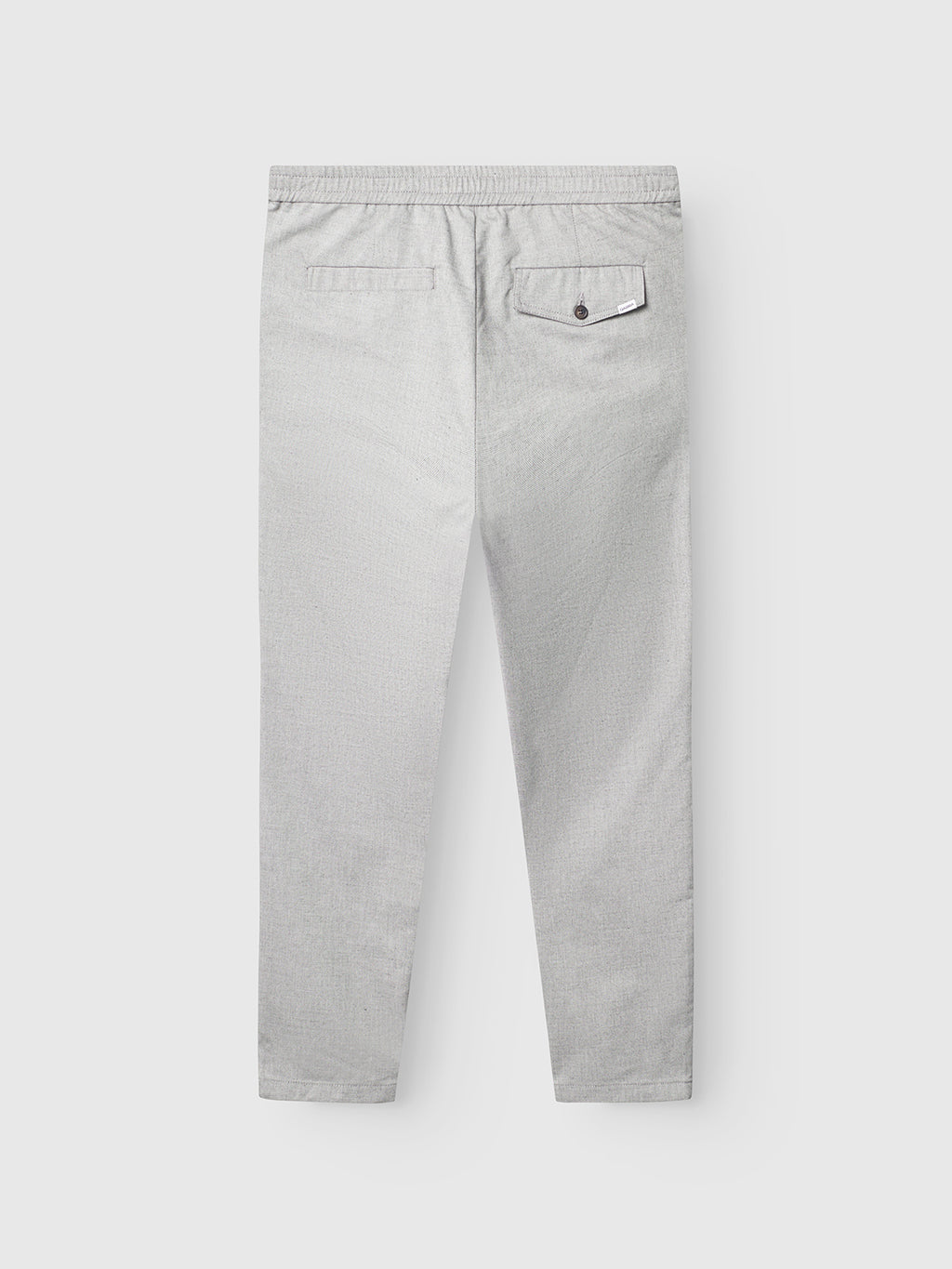 The Gabba Monza Button Carre in light grey is a relaxed straight pant, shown from the back with an elastic waist, left welt pocket, and right buttoned flap pocket. The versatile style is laid flat on a white background.