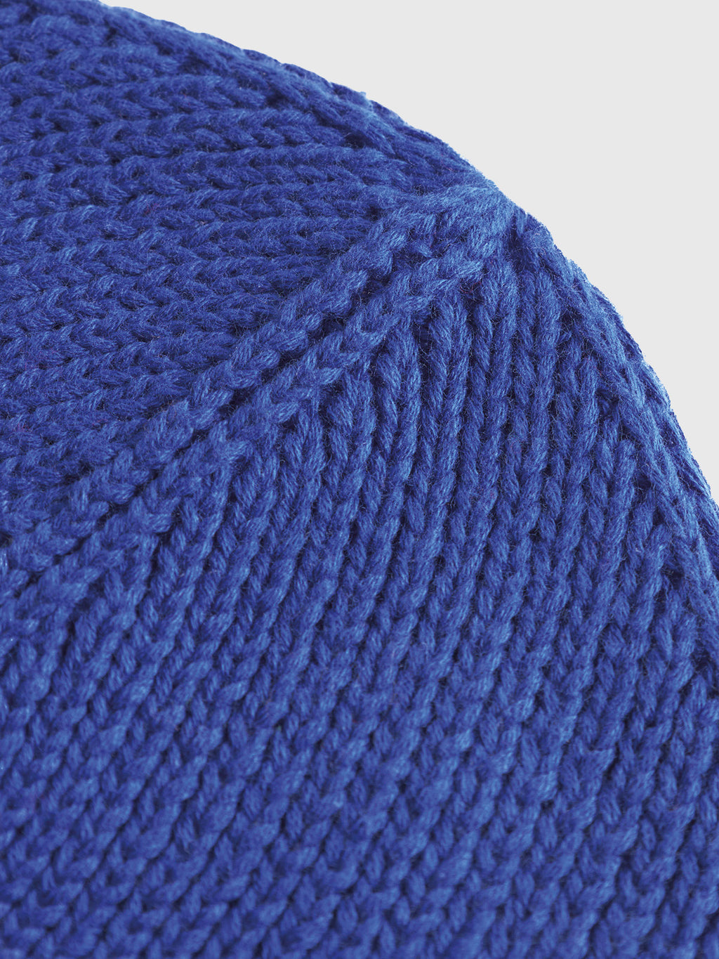 Close-up of the New Mount Beanie by Gabba in vibrant blue, showcasing its ribbed knit design with textured ridges and intricate stitching patterns.