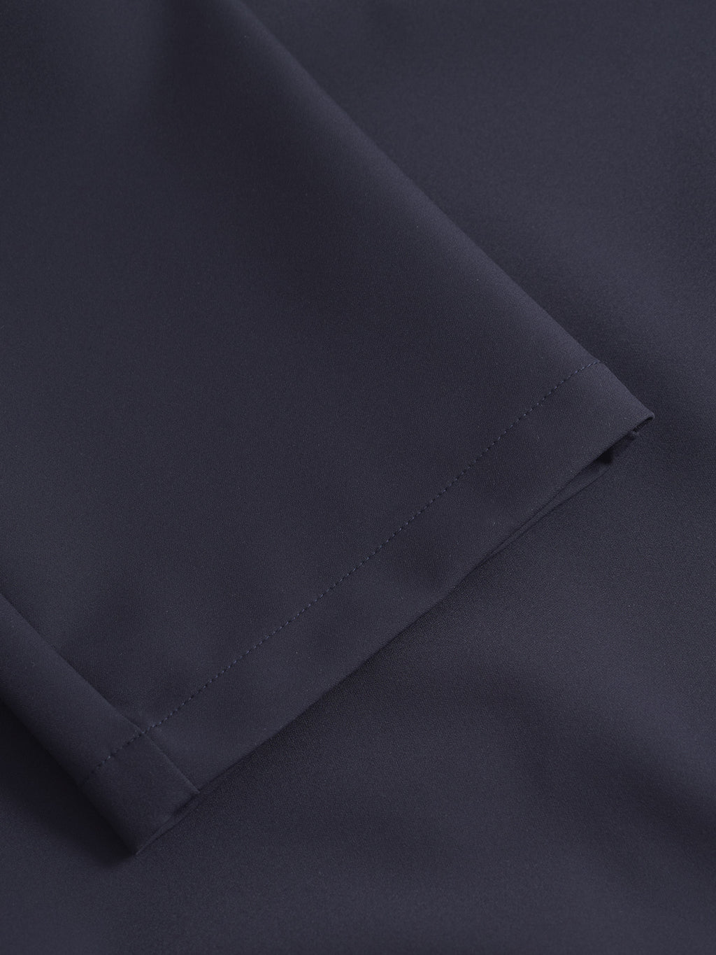 Close-up of the Monza Bascu - Navy fabric by Gabba, showing the dark navy color, smooth wrinkle-resistant texture, and neat stitching on the straight fit pant’s hem.