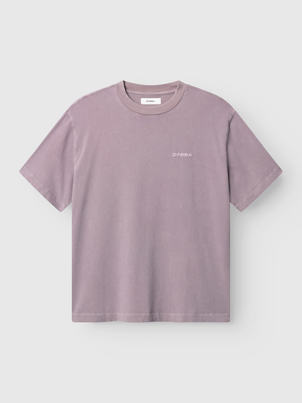 The Gabba Nigel Wix Boxy Peso SS in Dust Purple is a cotton jersey tee with a boxy fit, crew neck, short sleeves, and a small white logo on the left chest, shown on a clean white background.
