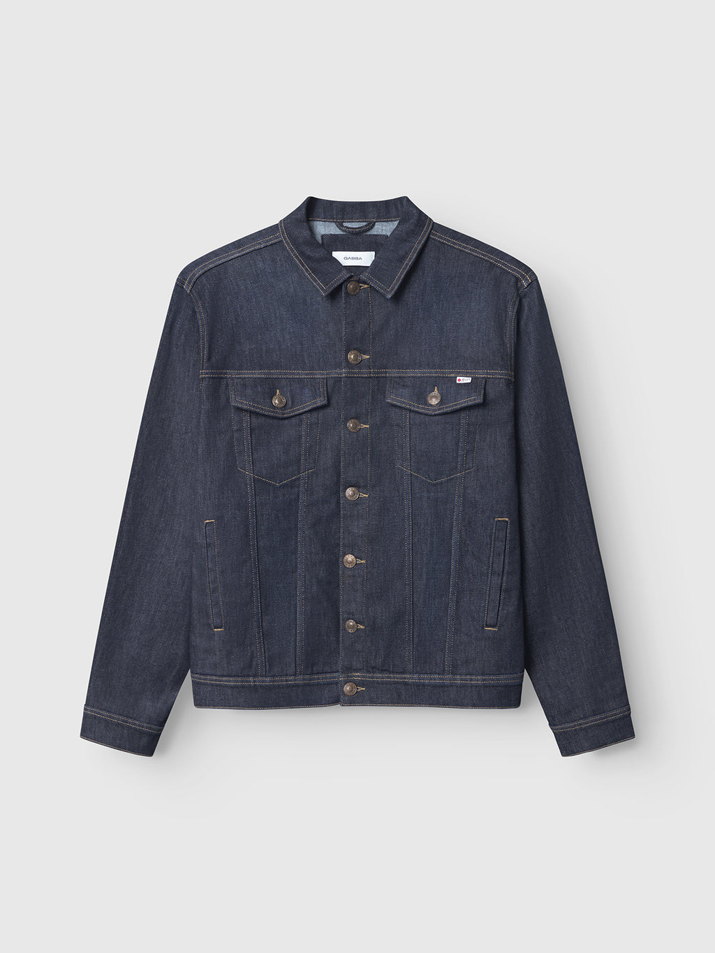 The Gabba Luca Self - Dark Blue Denim jacket features sustainable dark blue denim, a button-up front, two flap chest pockets, side pockets, and tan stitching. Shown against a plain light background.