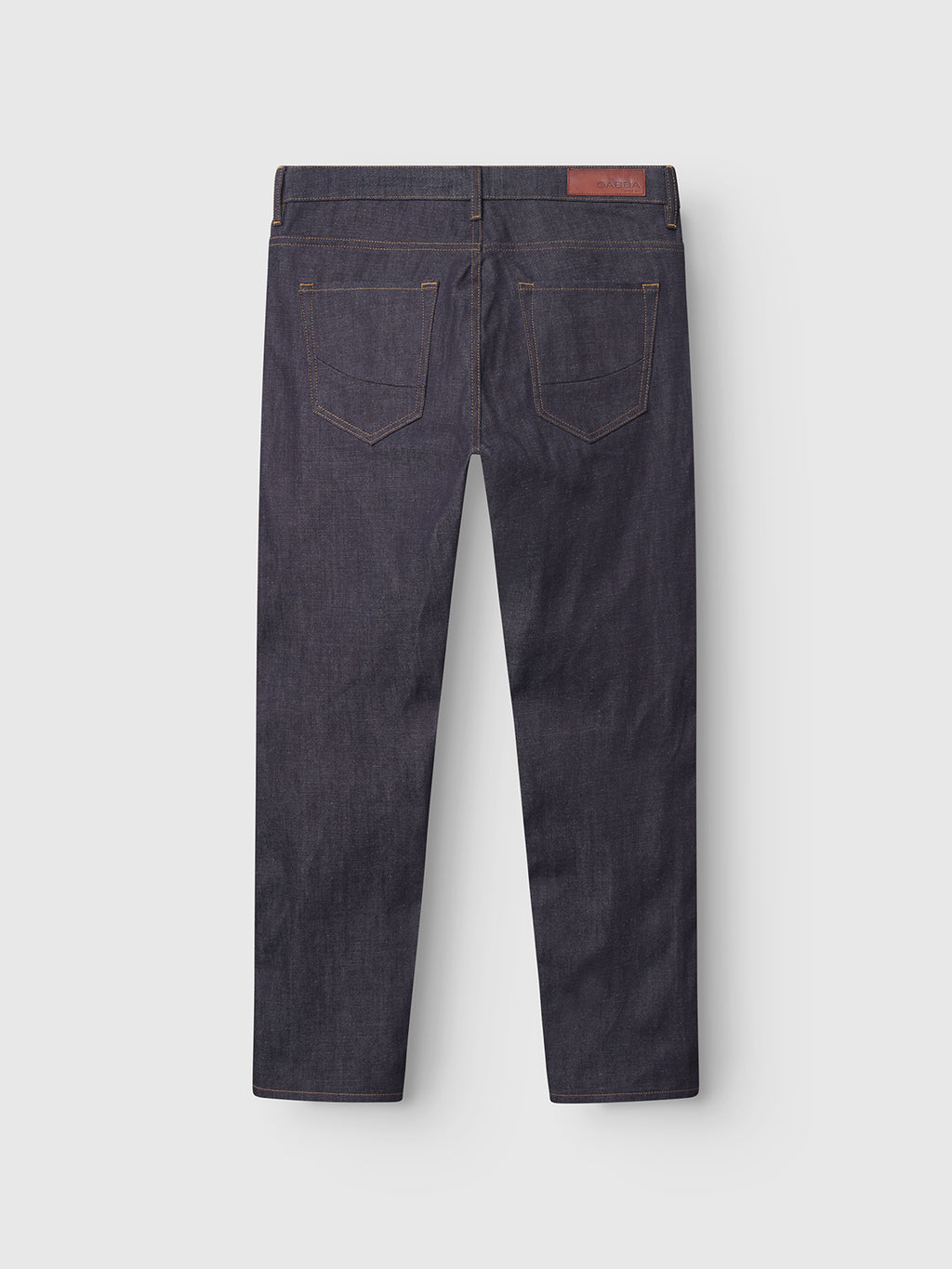 The Gabba Marc Tana - Dark Blue Denim jeans are shown from the back, with two rear pockets, brown stitching, and a brown leather patch on the waistband set against a plain light gray background.
