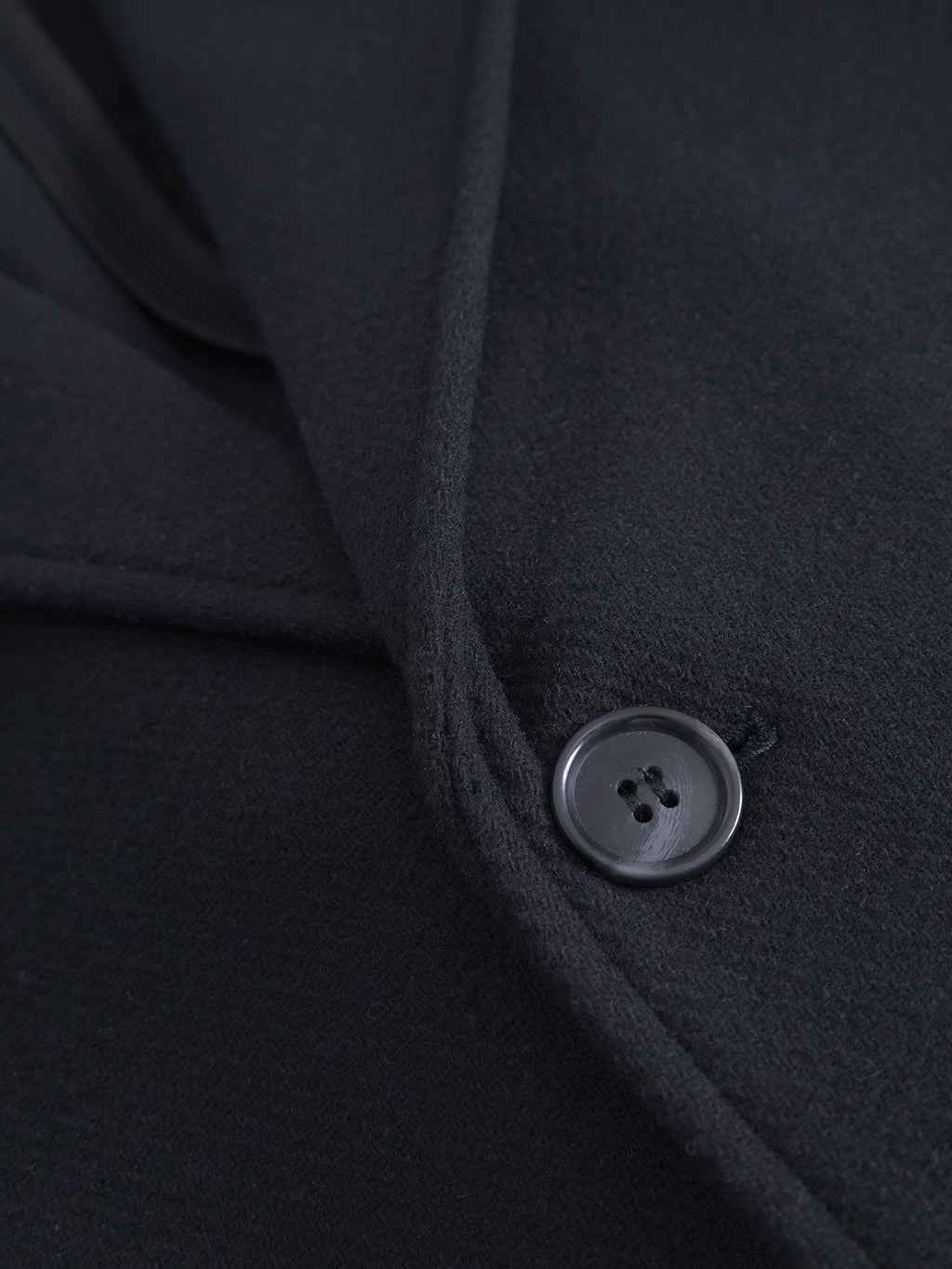 Close-up of Gabba's Leeds Drift - Navy oversized wool coat, showcasing a single black button and the soft, textured lapel edge.