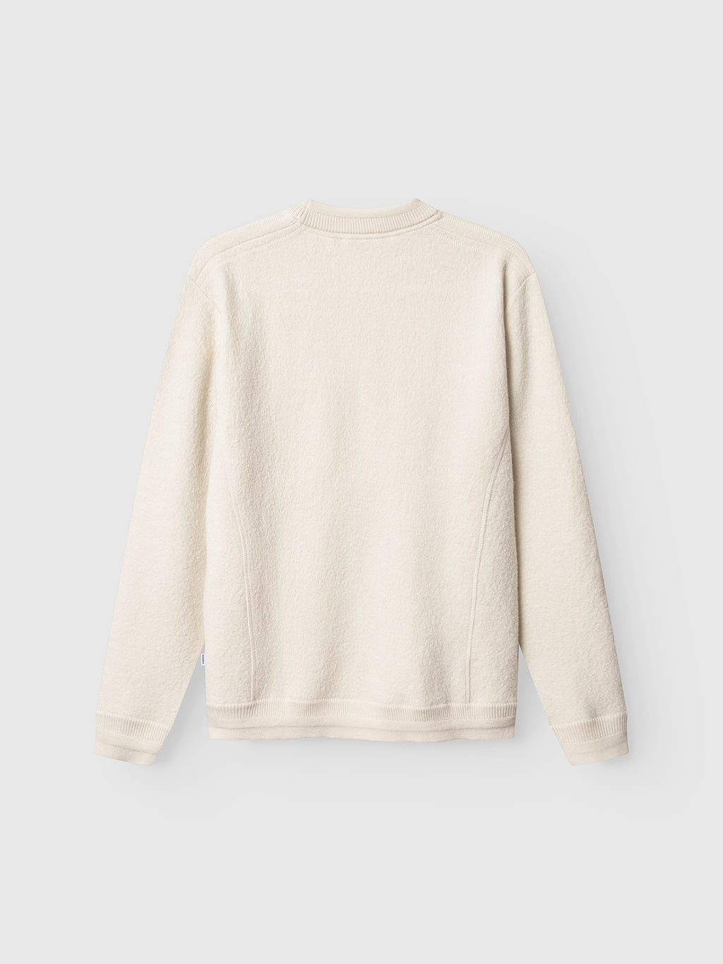 The Gabba Bristol Led sweater in White Almond is displayed flat, back view, on a light gray background. It features a minimalist design with ribbed cuffs, hem, and neckline for a clean look.
